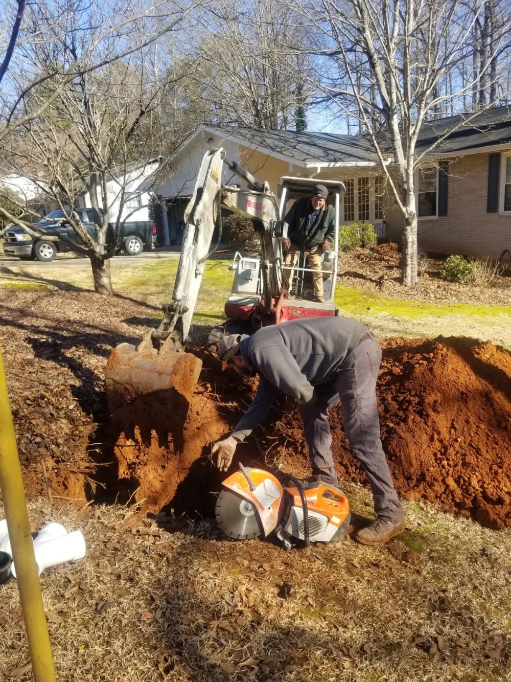 Mike's Plumbing technicians on a residential job site, excavating to reach a water line in Stockbridge, GA
